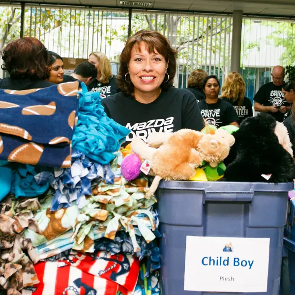 Volunteer with a stack of Blankets